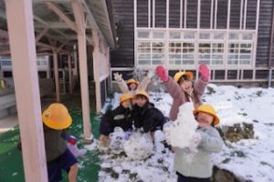 中庭で雪だるまを作る1年生